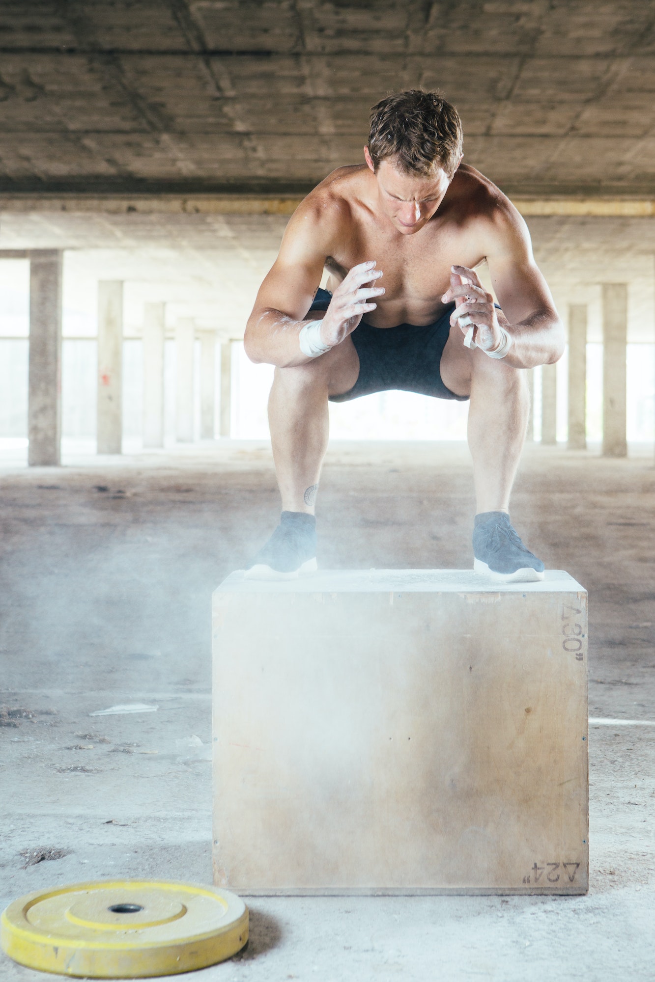 Muscular man doing box jumps